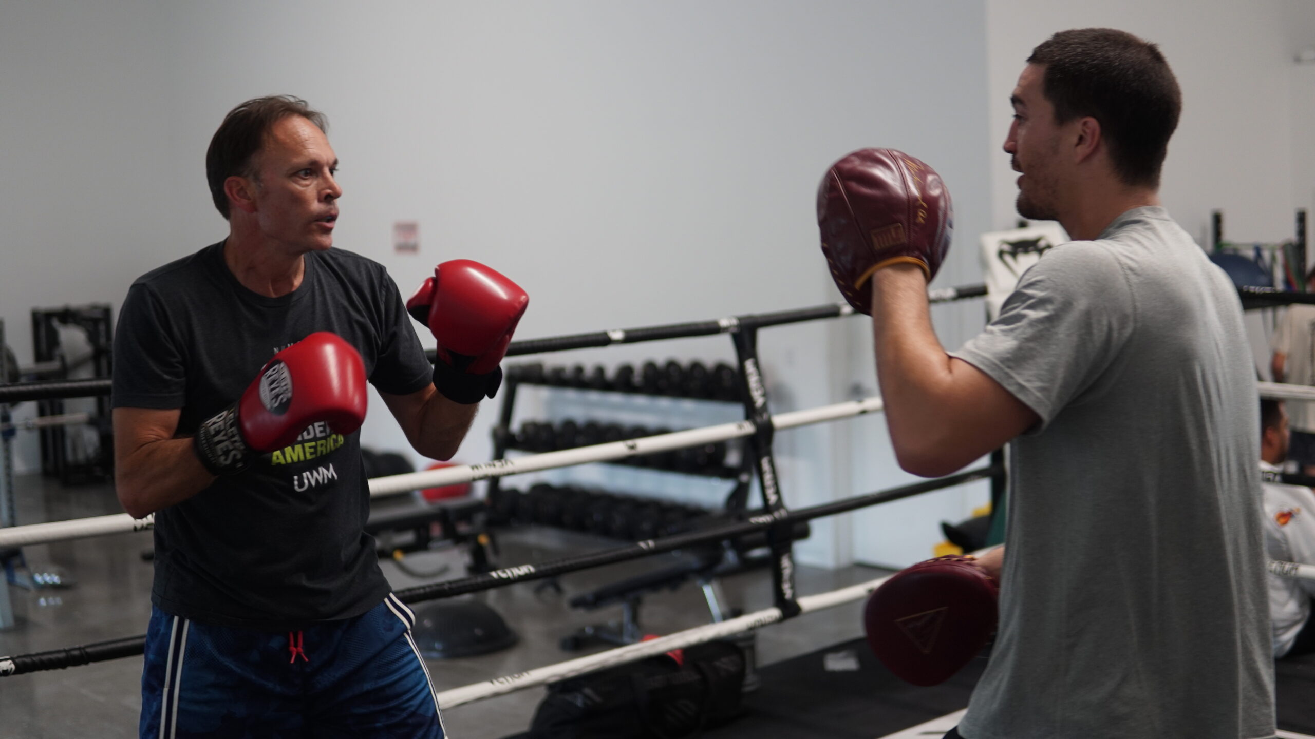 coach and a fighter working mitts